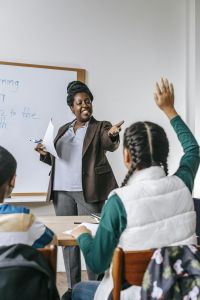 A teacher interacts with students in a classroom, fostering an engaging learning environment.